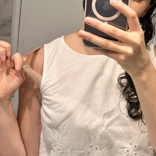 Fotografía estilo catálogo que muestra ropa interior color nude e invisible bajo una blusa blanca translúcida de la marca chilena Nubody.
